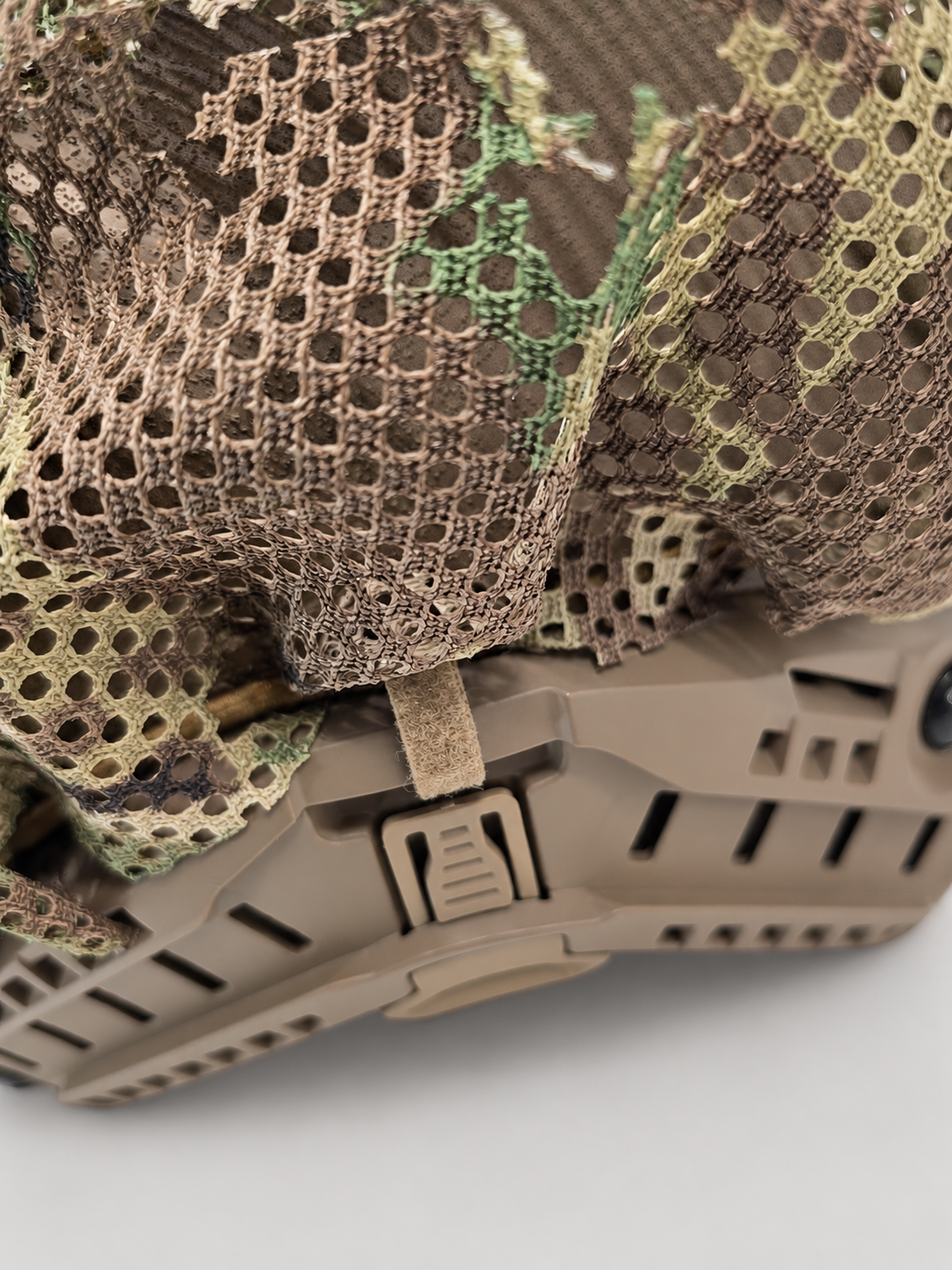Close-up of the Tatou Armor MultiCam mesh helmet cover on a tan tactical helmet